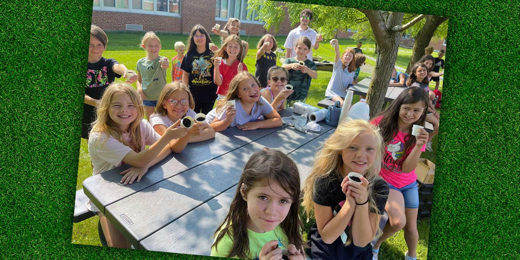 Community school students get some hands-on learning planting seeds.