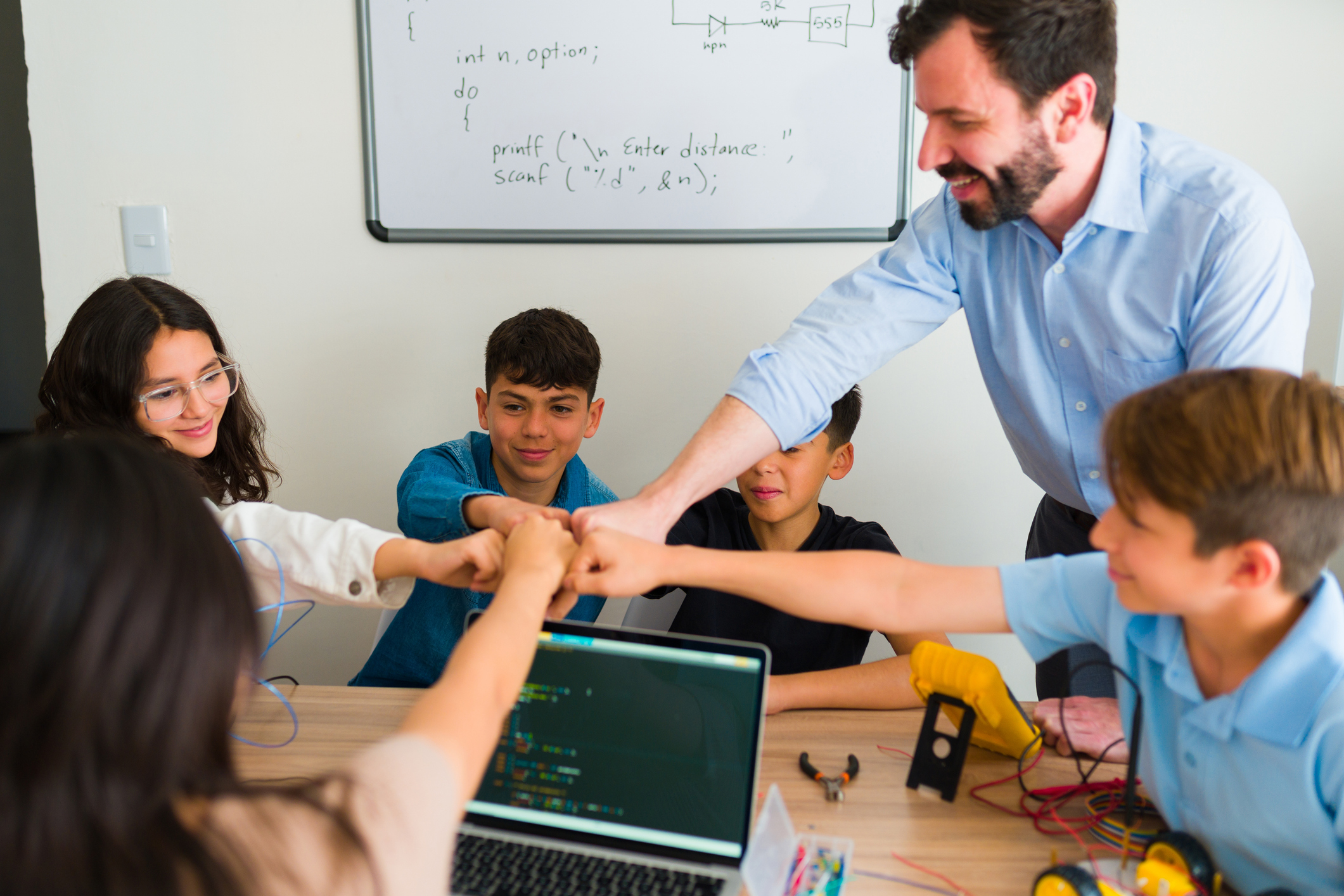 students and teacher fist bump