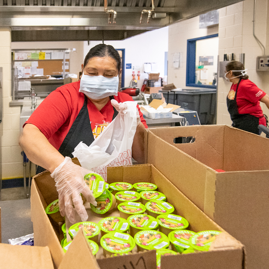 school meal waivers: a school food service professional prepares meals for students
